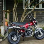 Après 41 ans d'absence, la motocyclette Dax de Honda s'apprête enfin à faire son retour en France aux côtés des modèles Monkey et MSX125 Grom dans la gamme unique de mini-motos du constructeur japonais. Honda Dax 2022 mini moto Plus qu'une mini moto, une icône de notre jeunesse L'emblématique cadre en T en acier embouti fait de la Dax une moto unique qui n'a rien à envier à ses concurrentes, grandes ou petites. S'étendant du dessous de la selle au guidon chromé, le cadre rappelle le teckel, ce mignon petit chien aux pattes courtes et au corps allongé qui a inspiré Honda pour nommer le premier modèle ST50 Dax à la fin des années 60. Le Dax 2023 conserve les lignes incomparables du modèle d'origine avec un cadre qui, en plus d'accueillir le réservoir de carburant, est capable de supporter le poids de deux adultes (attention quand même). La suspension est assurée par une fourche inversée de 31 mm et deux amortisseurs arrière. Le look est complété par des jantes noires de 12 pouces dans le style classique des mini-motos, montées sur des pneus à large section pour une manipulation facile en ville et pour absorber les bosses les plus prononcées. Parmi les autres détails élégants, citons les feux à LED, un écran LCD compact rétroéclairé, un guidon chromé et une barre de maintien pour le passager. Propulsé par un moteur de 124 cm3, à arbre unique, refroidi par air, qui délivre une puissance et un couple très doux, le Dax est doté d'un embrayage centrifuge automatique et d'une boîte de vitesses à quatre rapports pour une expérience de conduite détendue et amusante, en solo ou avec un partenaire. La ST125 DAX sera disponible en Europe en livrée rouge nébuleux, avec l'aile classique Honda et le logo stylisé du teckel. Ça vous donne envie de remonter dessus comme un adolescent n'est-ce pas? Retrouvez plus d'actualités automobiles et moto sur notre média Linline