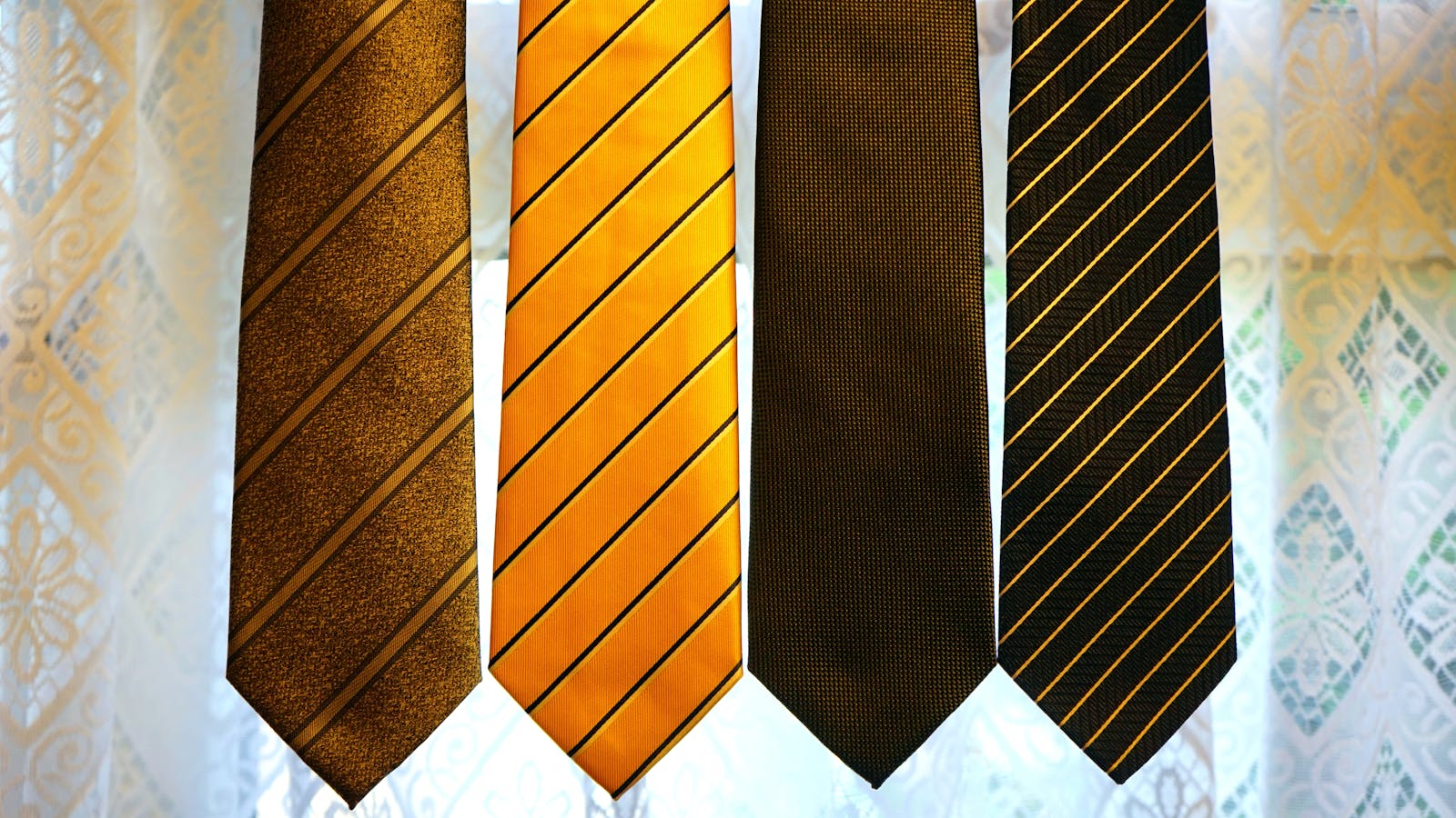 Quatre cravates de couleurs assorties sur textile gris