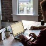 homme utilisant un ordinateur portable sur une table pour la création d'un site internet sur mesure