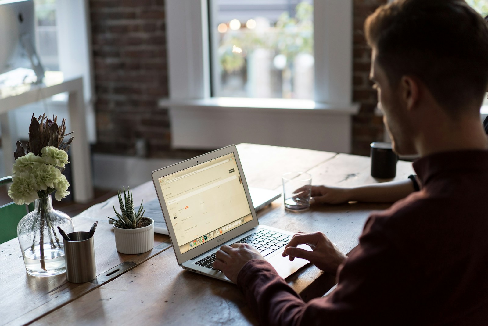 homme utilisant un ordinateur portable sur une table pour la création d'un site internet sur mesure